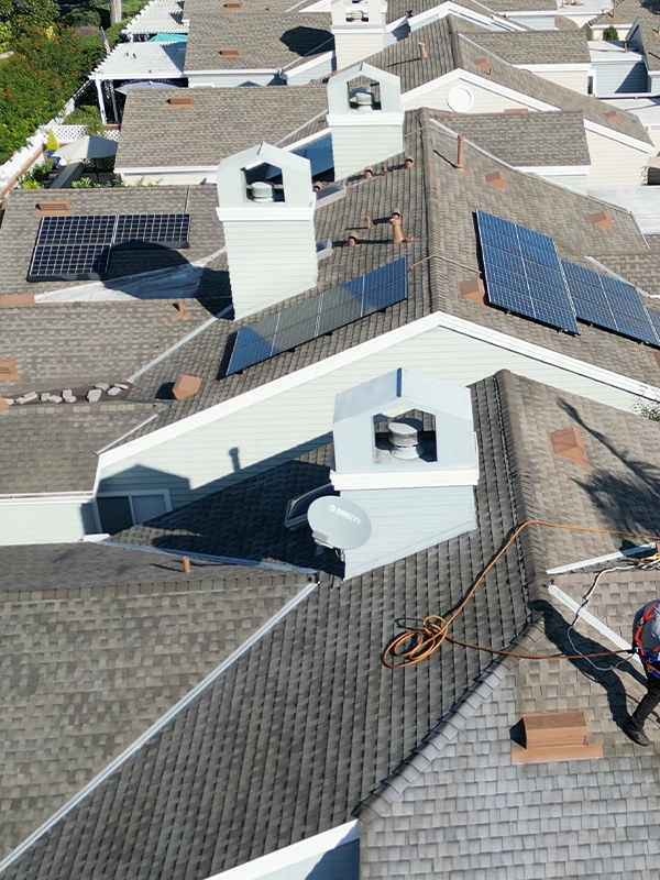 Aerial view of a Florida home with solar attic fans and solar panels installed on the asphalt shingle roof